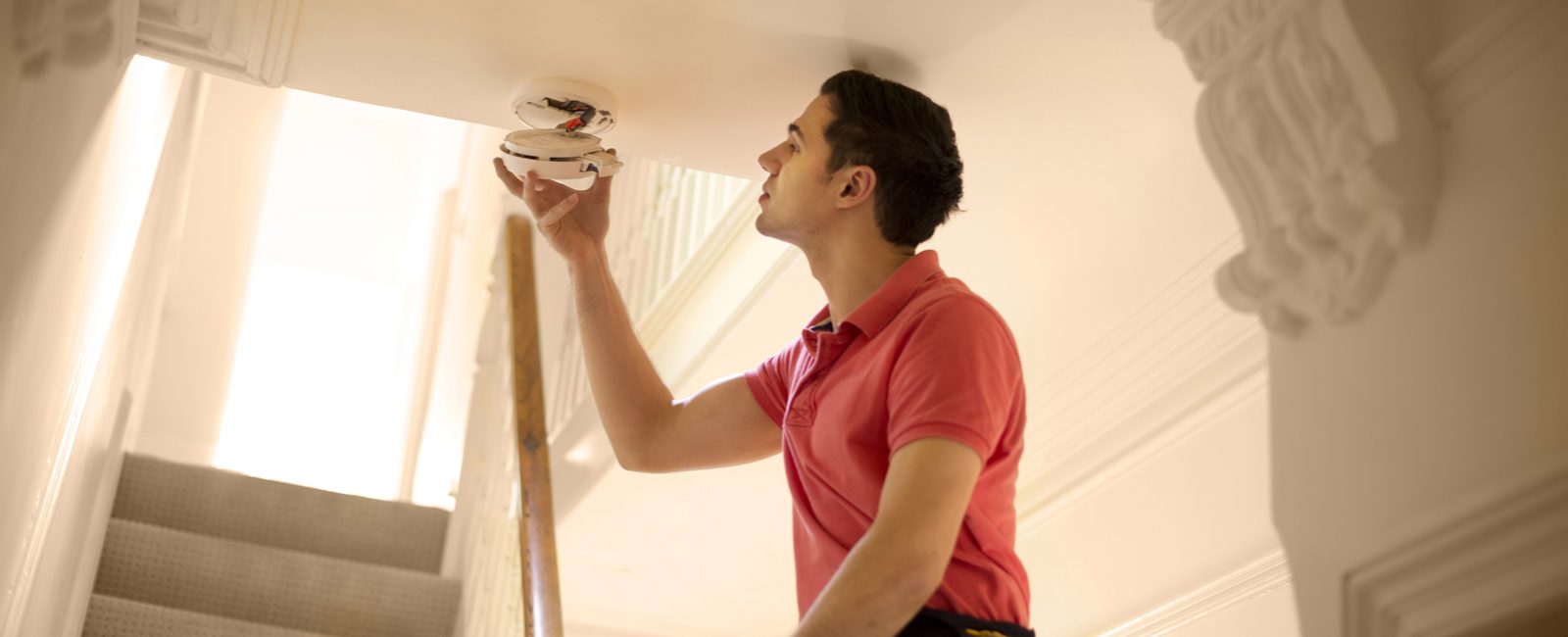 Stock man checking smoke alarm