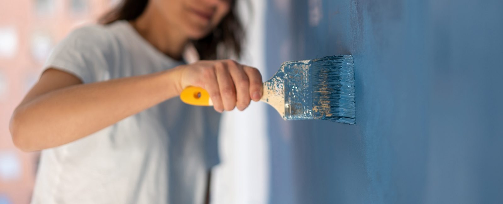 Stock woman painting wall